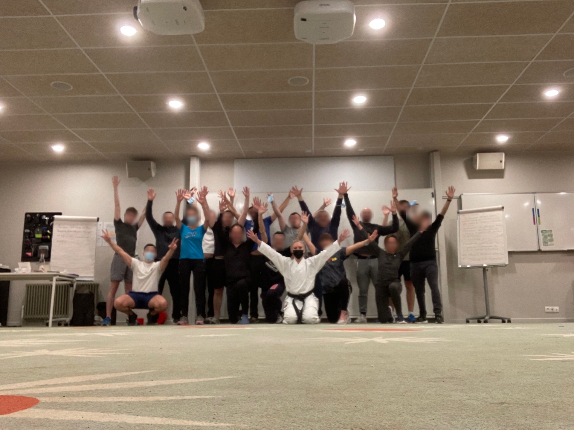 Groupe en initiation au karaté en salle, les bras levés avec Caroline Desmazures